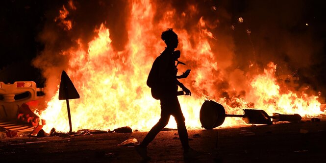 Demonstrant vor brennender Barrikade