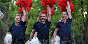 Männliche Cheerleader mit bunten Puscheln