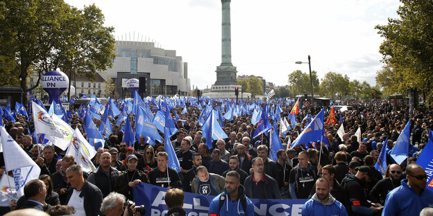 Eine Menschenmenge mit vielen blauen Fahnen