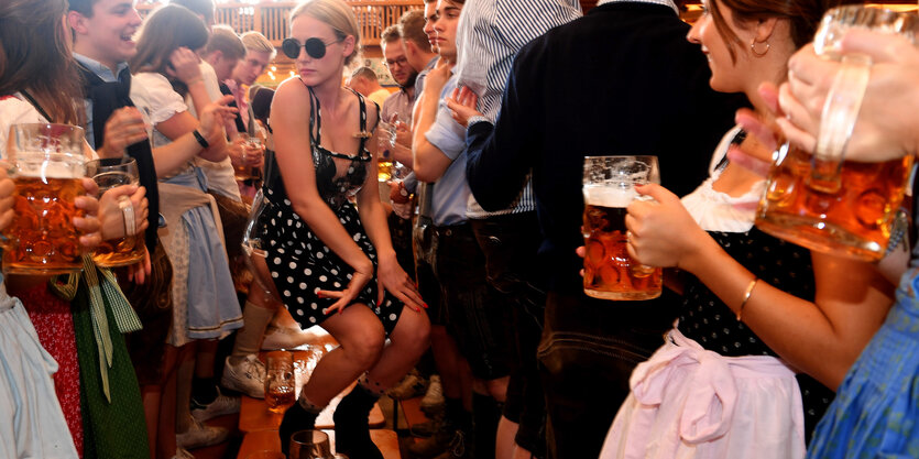 Eine Frau mit teilweise transparentem Kleid tanzt auf dem Tisch auf dem Oktoberfest