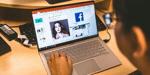 Eine Person surft auf ihrem Laptop und hat Facebook geöffnet