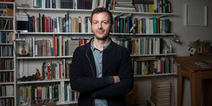 Dere Berliner Kleinverleger Sebastian Guggolz vor einer Bücherwand