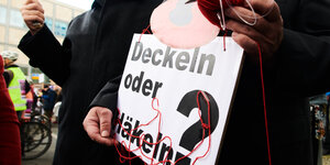 Teilnehmer bei Berliner Mietendemo mit Schild:Deckeln oder Häkeln?