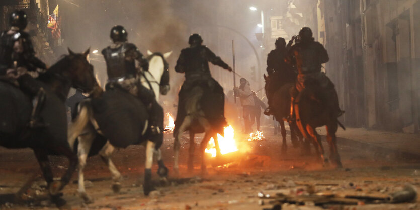 03.10.2019, Ecuador, Quito: Polizistenh sind mit Pferden bei einem Protest gegen die Erhöhung von Spritpreisen im Einsatz. Ecuadors Präsident Moreno hat wegen Protesten gegen Preiserhöhungen bei Treibstoffen den Ausnahmezustand in dem südamerikanischen La