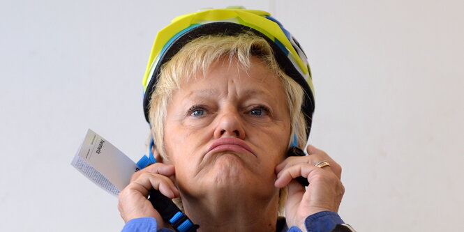 eine Frau mit einem Fahrradhelm zieht einen Flunsch