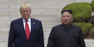 Donald Trump und Kim Jong Un stehen nebeneinander