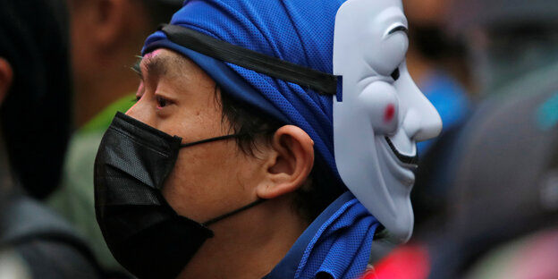 Ein Demonstrant trägt zwei Masken