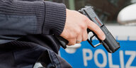 Ein Polizist hält eine Waffe in der Hand