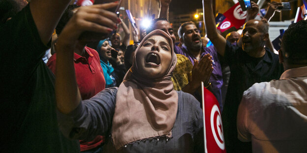 Eine Menschenmenge mit tunesischen Fahnen feiert