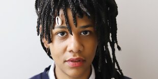 Porträtaufnahme einer jungen Frau mit Dreadlocks