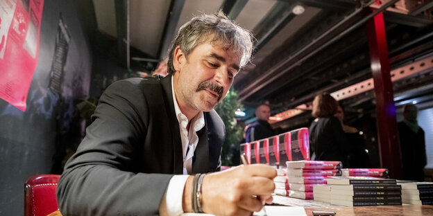 Der "Welt"-Journalist Deniz Yücel unterschreibt sein Buch "Agentterrorist" bei seiner Buchpremiere im Festsaal Kreuzberg