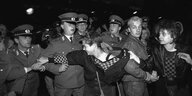 Eine Frau versucht eine Demonstrantin von einer Polizeikette weg zu ziehen