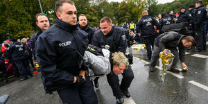 Polizisten tragen einen Aktivisten der Klimabewegung "Extinction Rebellion" während der Aktionswoche "Berlin blockieren" von einer Sitzblockade am Großen Stern an der Siegessäule