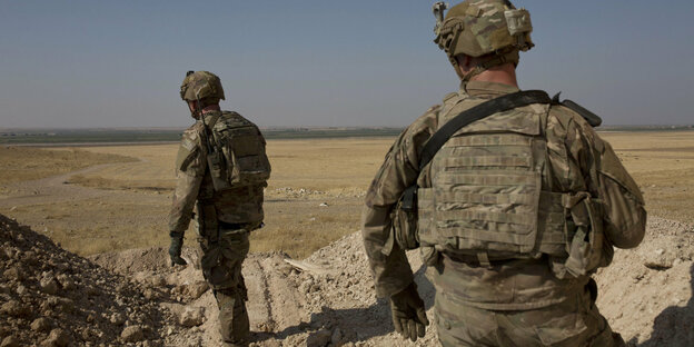 Zwei US-Soldaten in Uniform von hinten an der syrisch-türkischen Grenze