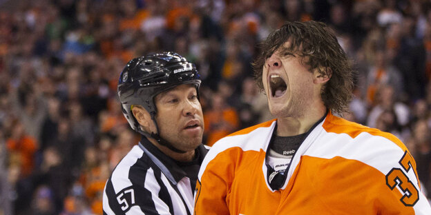 Der Philadelphia Flyers Jay Rosehill trägt ein orangnes Trikot und schreit vor Wut