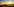 Nebelschwaden ziehen im Licht der aufgehenden Sonne über Felder mit einem Windrad.