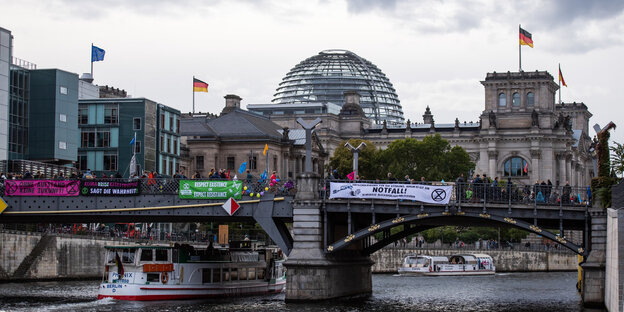 Demonstranten auf einer Brücke über der Spree, im Hintergrund die Reichstagskuppel