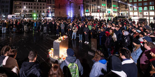 Menschenmenge steht um brennede Kerzen