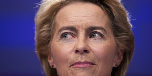 Ursula von der Leyens Gesicht ist vor einem blauen Hintergrund zu sehen.