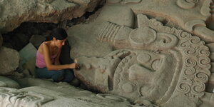 Eine Archäologin bei der Freilegung der monolithischen Stein in Mexiko-Stadtskulptur der Göttin Tlaltecuhtli