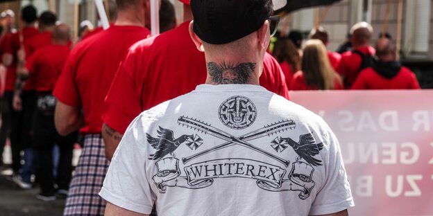 Ein Mann von hinten. Auf seinem T-Shirt steht "White Rex"
