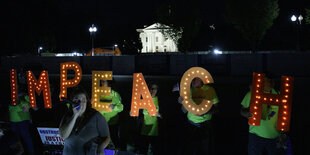 Leuchtbuchstaben in der Nacht formen das Wort IMPEACH