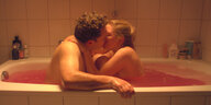 Zwei Menschen küssen sich in einer Badewanne