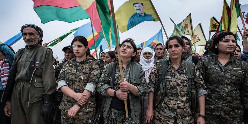 Frauen in Militäruniformen schwenken Fahnen