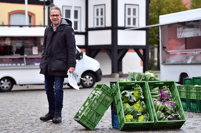 Mann steht neben Kohlkisten