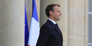 Macron mit stolzer Brust vor französischer Flagge