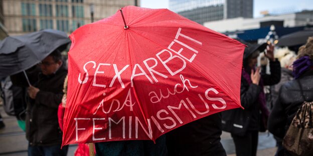 Roter Regenschirm mit der Aufschrift "Sexarbeit ist auch Feminismus"