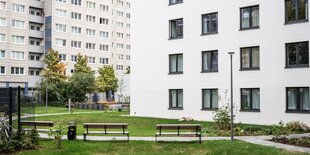 Eines der Häuser von House of Nations. Eine weisse Fassade mit vielen Fenster, davor ein Rasen und zwei Sitzbänke.