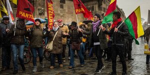 Menschen schwenken auf einer Demo Fahnen, auf denen „Partizan“ zu lesen ist