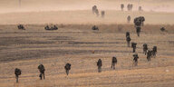 Soldaten marschieren auf einem Stoppelfeld