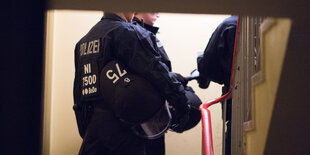 Polizisten stehen in einem Hausflur