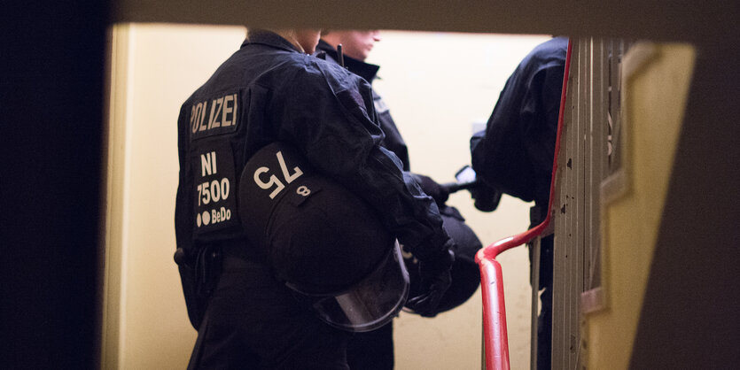 Polizisten stehen in einem Hausflur