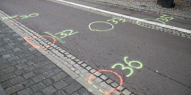 Farbige Kreise und Zahlen auf den Asphalt einer Straße gesprayt