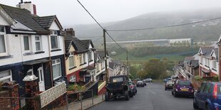 Straße mit englischen Reihenhäusern führt in unbebautes Gebiet