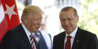 Trump und Erdogan stehen nebeneinander. Im Vordergrund am Rand steht eine Flagge der USA.
