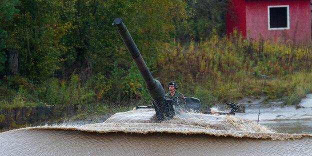 r: Ein Kampfpanzer der Bundeswehr vom Typ «Leopard 2A6» fährt durch ein Wasserbecken.