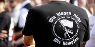 Auf dem T-Shirt eines Neonazis steht auf dem Rücken "Wir klagen nicht, wir kämpfen"