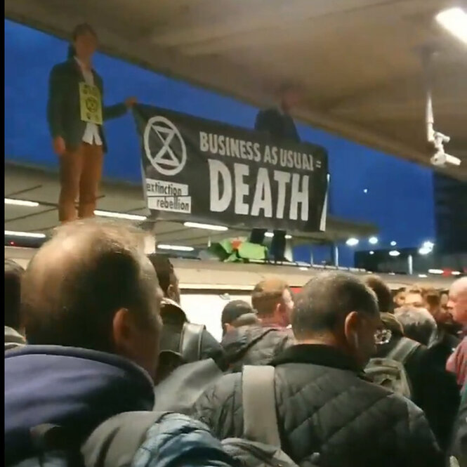 "Extinction Rebellion" stehen auf dem Dach einer U-Bahn im Bahnhof Canning Town