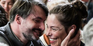 Ein Mann mit Bart umarmt eine grinsende Frau.