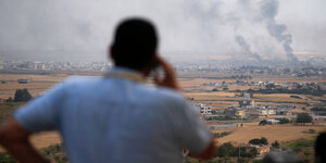 Ein Mann blickt von der türkischen Seite auf die syrische Stadt Ras al-Ain