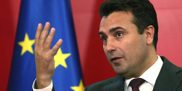 Der nordmazedonische Regierungschef Zaev gestikuliert vor einer EU-Flagge.
