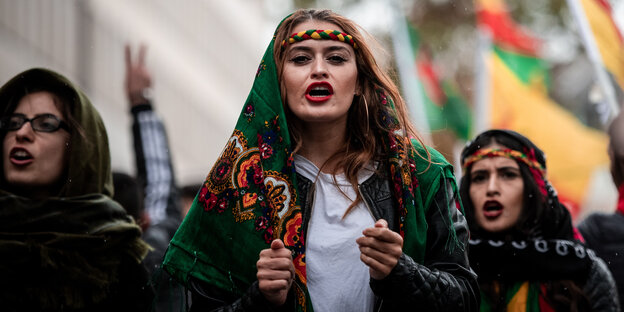 Mehrere Frauen demonstrieren in Köln; die Frau in der Mitte hat sich ein grünes Tuch umgehängt.