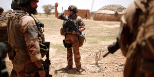 Soldaten in Tarnkleidung lauschen beim Einsatz in der Wüste den Erklärungen ihres Kommandanten