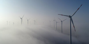 Mehrere Windkrafträder im Nebel