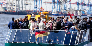 Menschen stehen auf dem Deck einer Hafenfähre