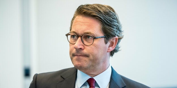 Bundesverkehrsminister Andreas Scheuer blickt mit zusammengekniffenen Lippen in die Ferne